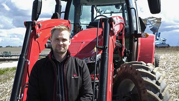 Varaosien myyntipäällikkö Jan-Miikkael Rytsälä kuvattuna Massey Ferugson -traktorin edessä