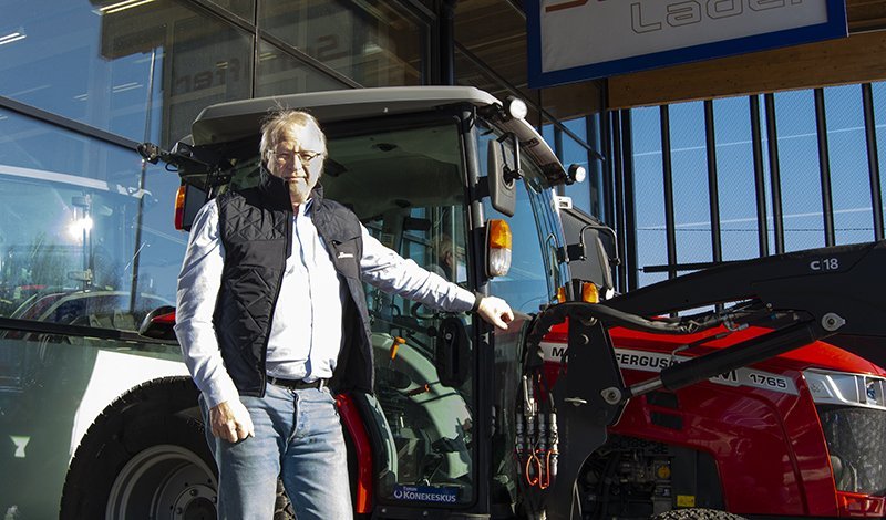 Turun Konekeskuksen Jouni Oksanen seisoo Turun myymälän edustalla Massey Ferguson -traktorin kanssa