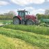 Kesäisellä pellolla työskentelemässä Massey Ferguson -traktori sekä McHale ProGlide -niittokoneet