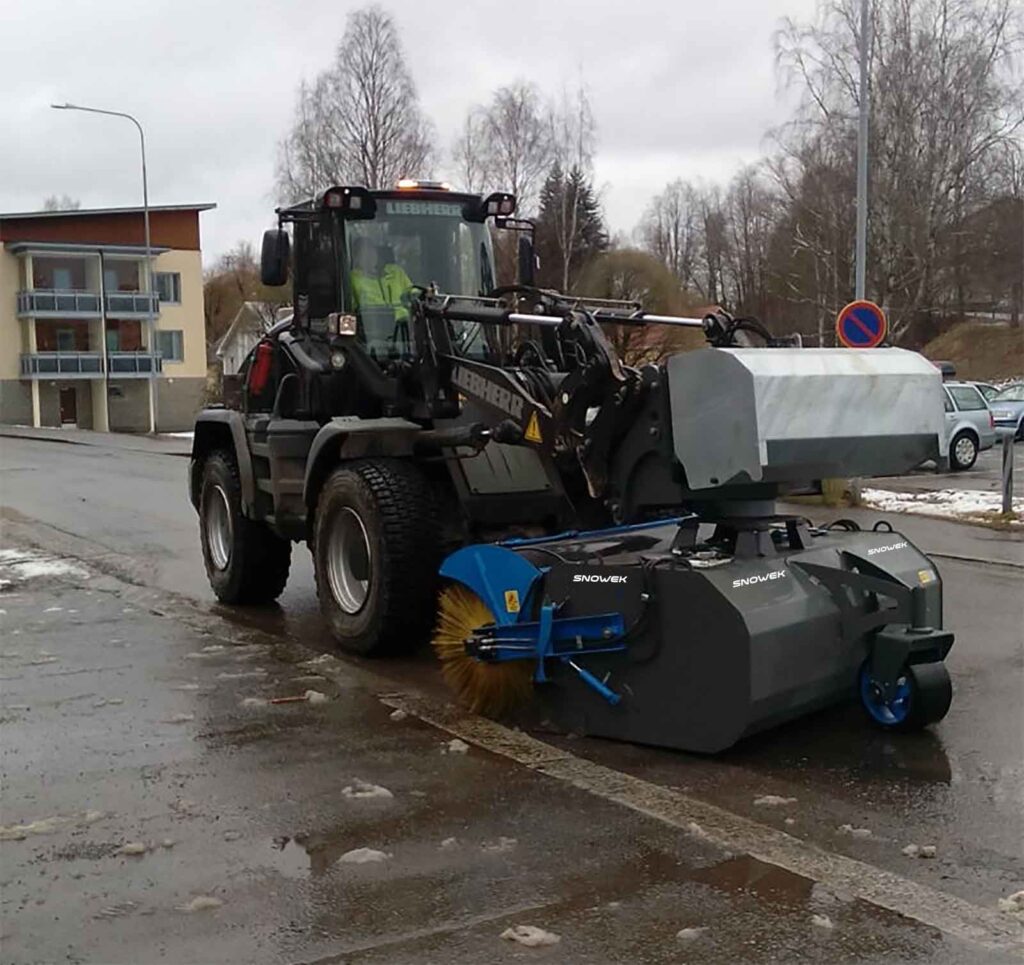 Snowek Circulus harjakone puhdistaa tien reunaa.