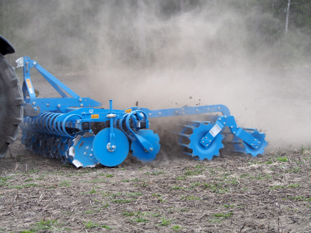 Lemken Heliodor -lautasmuokkain pellolla muokkaamassa, jossa maatalouskoneen jälkipakkerit mahdollistavat oikeanlaisen maan tiivistymisen.
