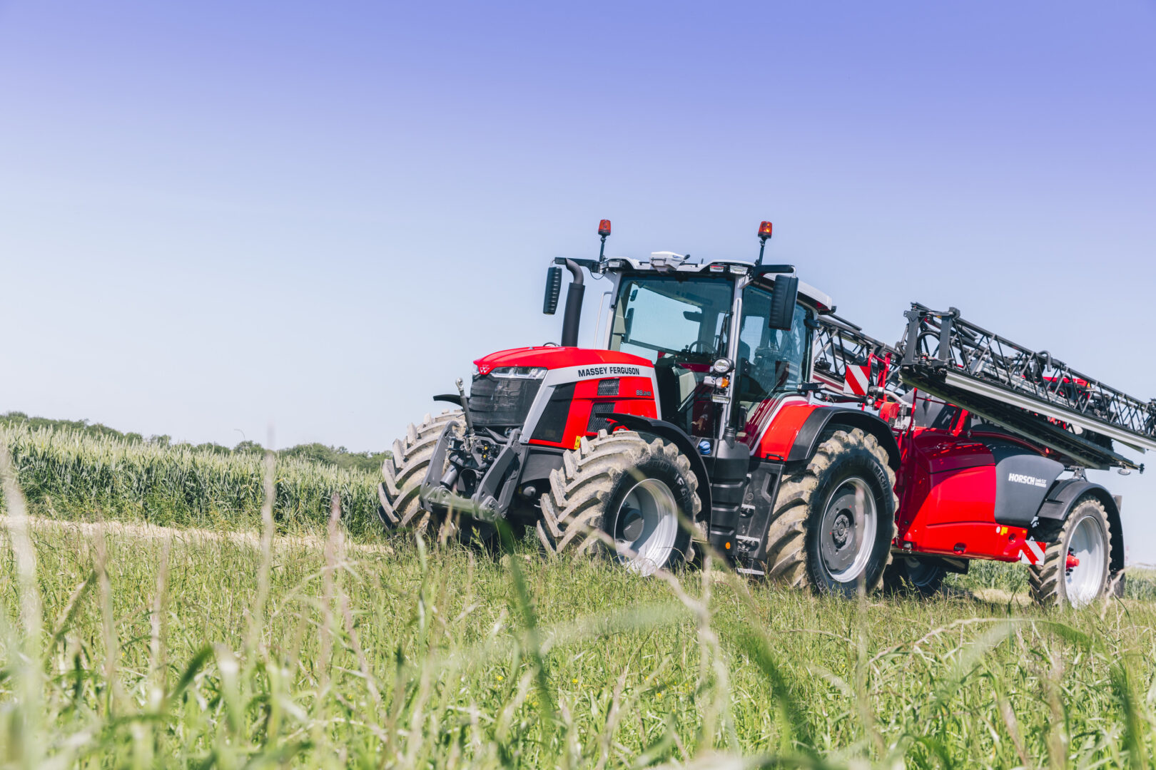 Massey Ferguson 8S -traktori ja Horsch -kasvinsuojeluruisku ajamassa pellolle.