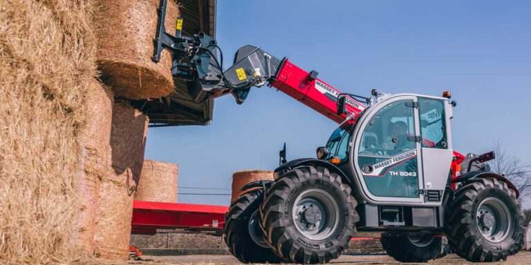 Massey Ferguson kurottaja nostaa paalia.
