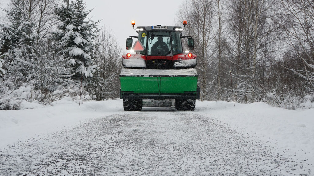 Sami SL-hiekoitin levittää sepeliä tielle.