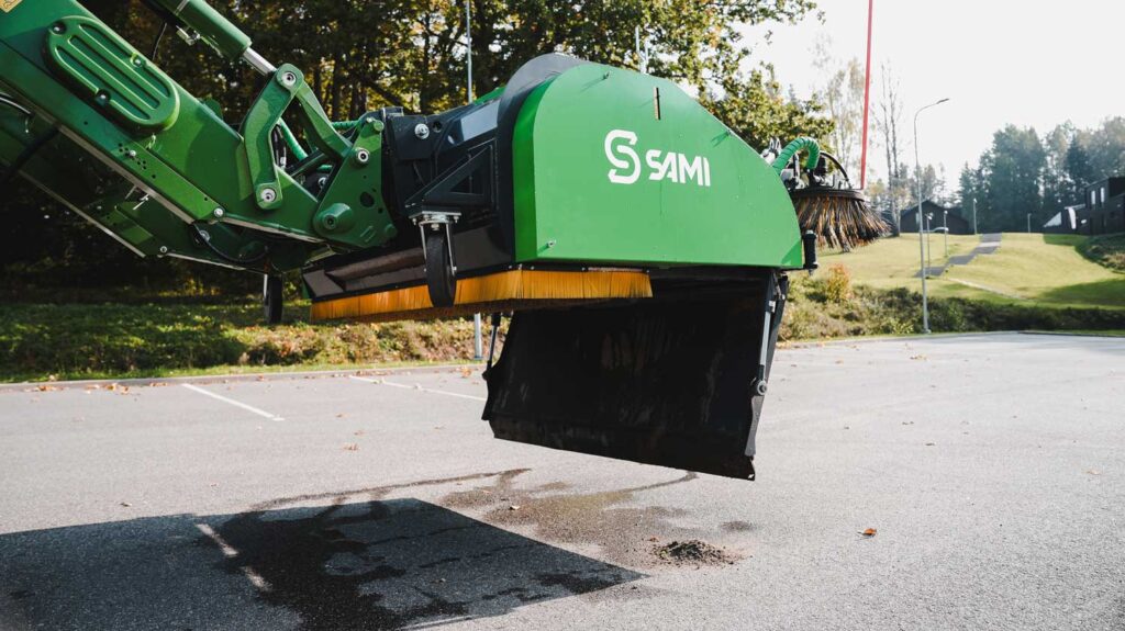 Sami keräävä harjakone tyhjentää roskat.