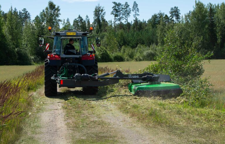 Sami-ketjumurskain ja MF-traktori pientareita leikkaamassa.