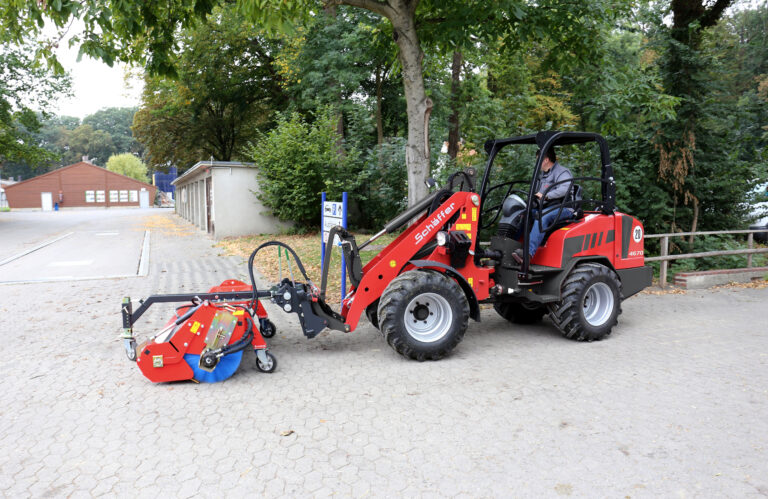 Schäffer 4670 pienkuormaaja ja harjakone katujen puhdistukseen.