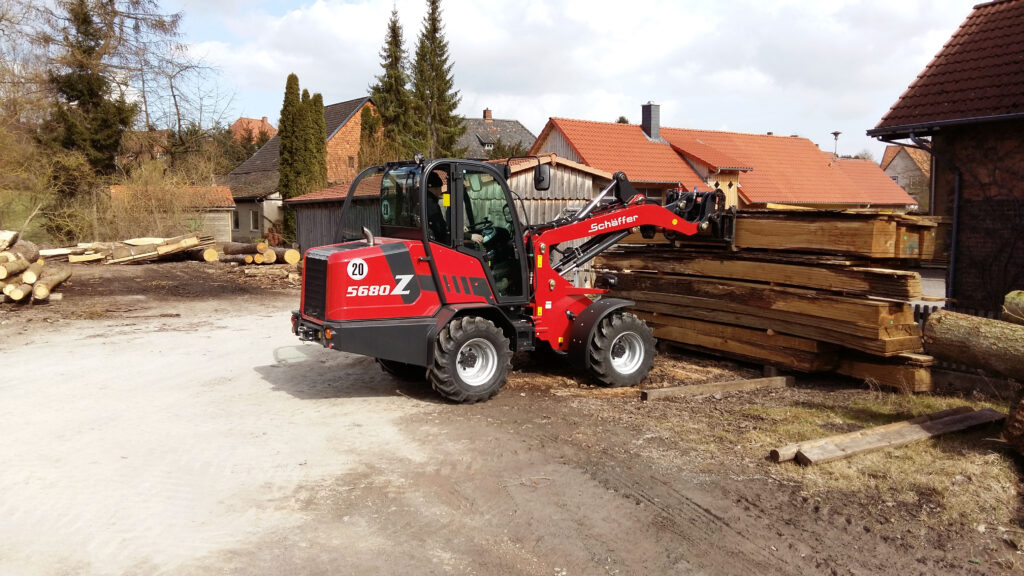 Schäffer 5680 Z pyöräkuormaaja nostaa tukkeja.