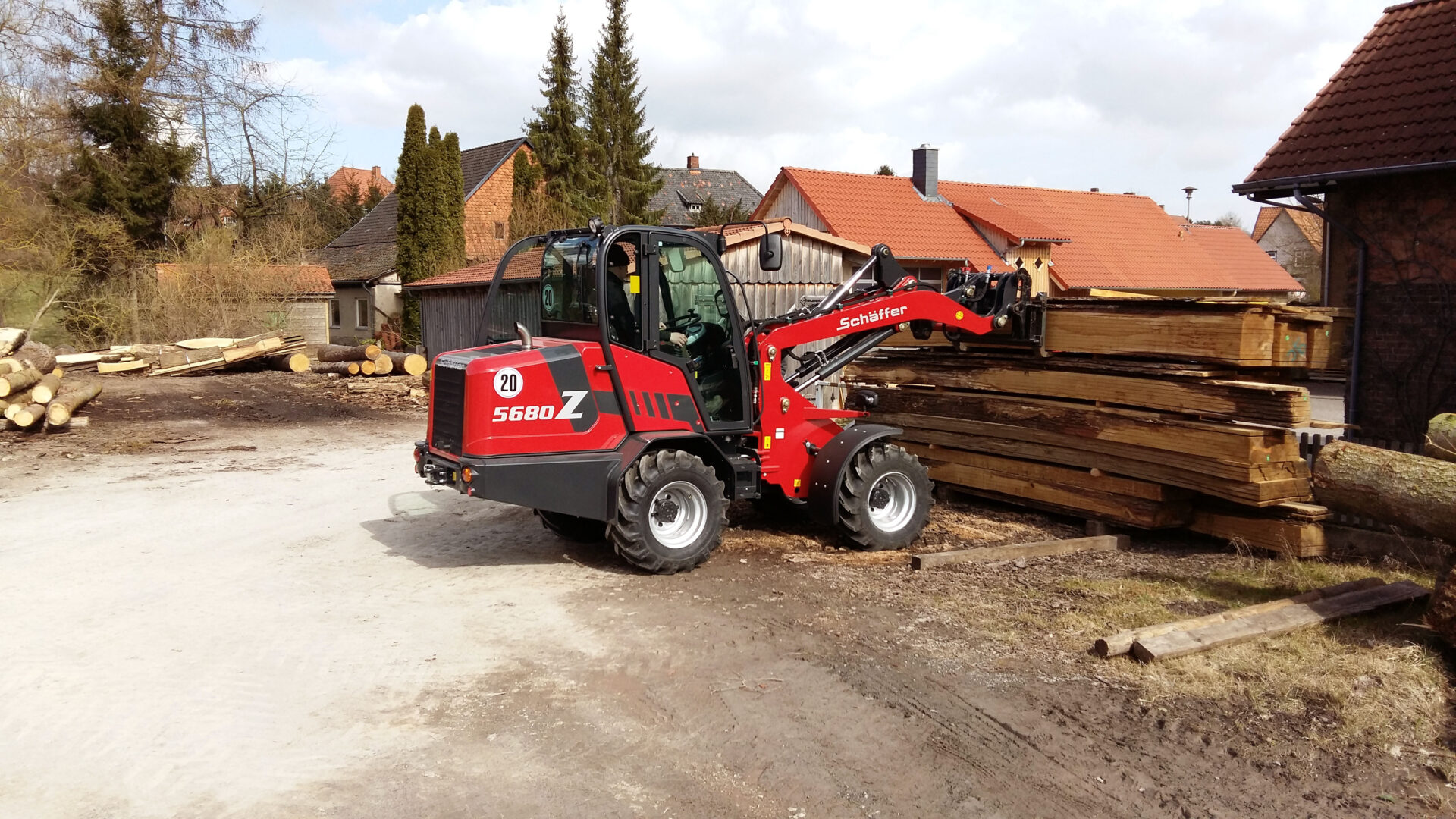 Schäffer 5680 Z pyöräkuormaaja nostaa tukkeja.
