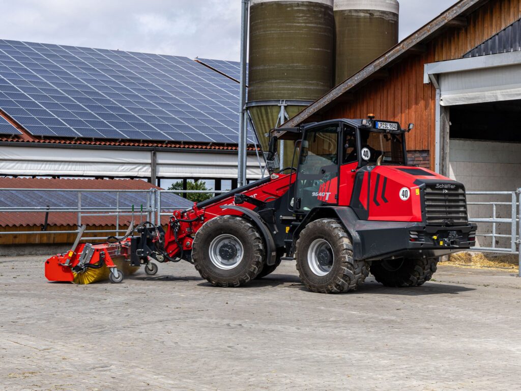 Schäffer 9640 T-3 -teleskooppikuormaaja lakaisemassa pihaa-