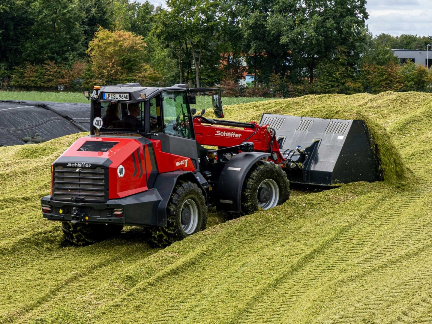 Schäffer 9640 T-3 -teleskooppikuormaaja työntämässä säilörehua aumassa.