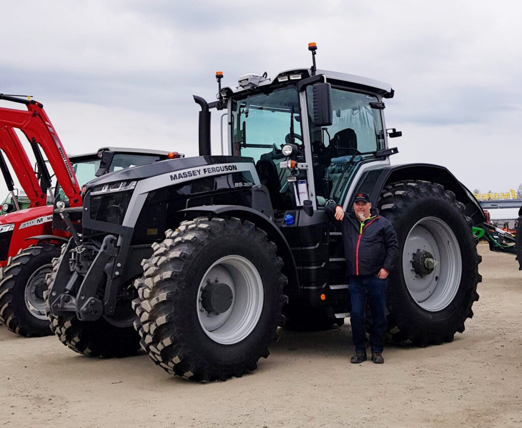 Asiakkaamme Antti Haataja mustan MF By You Massey Ferguson -traktorin edessä.