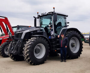 Asiakkaamme Antti Haataja mustan MF By You Massey Ferguson -traktorin edessä.