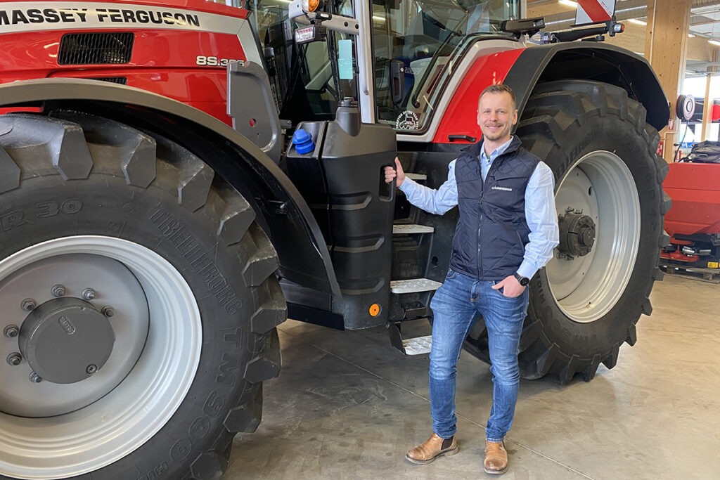 Lapin traktorimyyjä Henrik Eero Massey Ferguson -traktorin vieressä.