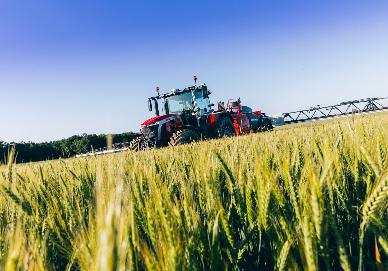Massey Ferguson 8S -traktori ja Horsch Leeb -kasvinsuojeluruisku levittämässä kasvinsuojeluainetta pellolla.