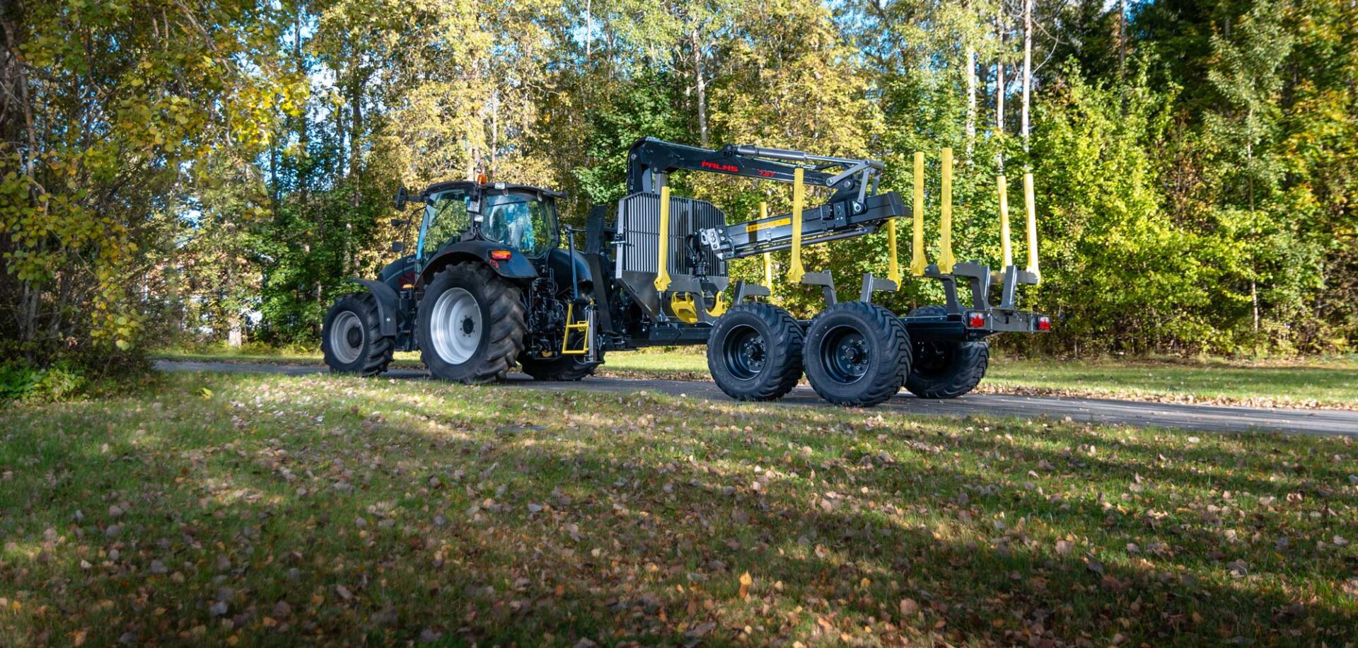 Palms 7.87 metsäkuormain ja kärry traktorin perässä.