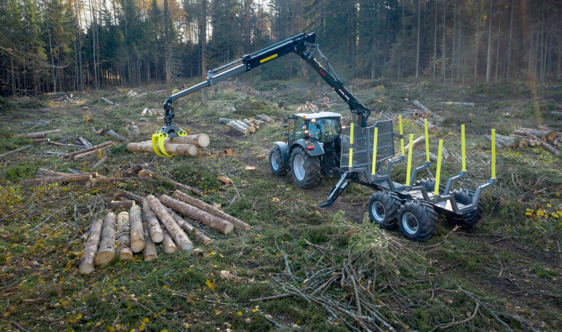 Palms 7.94 metsäkuormain lastaamassa puita metsäkärryyn metsässä.