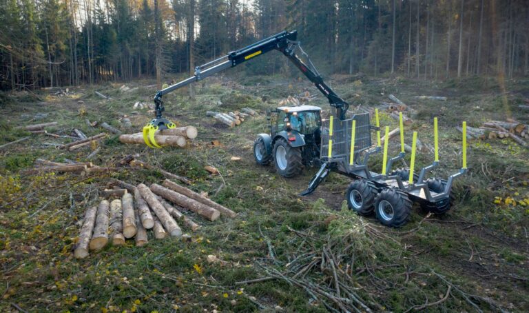 Palms 7.94 metsäkuormain lastaamassa puita metsäkärryyn metsässä.