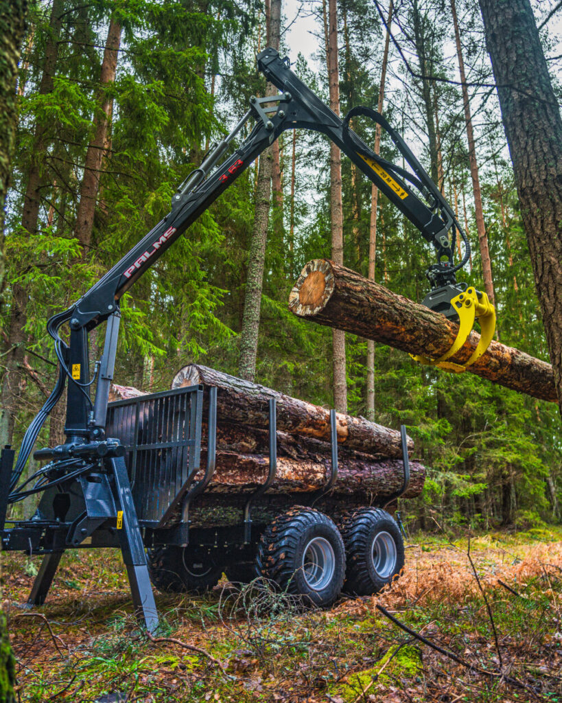 Palms 3.63 metsäkuormain nostaa puun kärryyn.