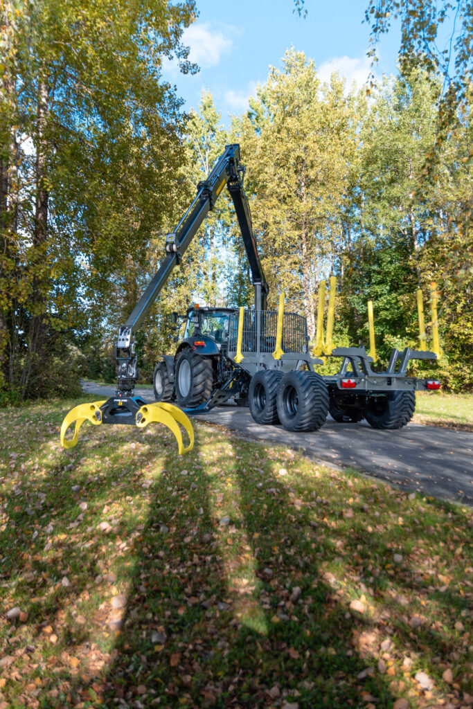 Palms 7.87 metsäkuormain ja kärry traktorin perässä, koura auki.
