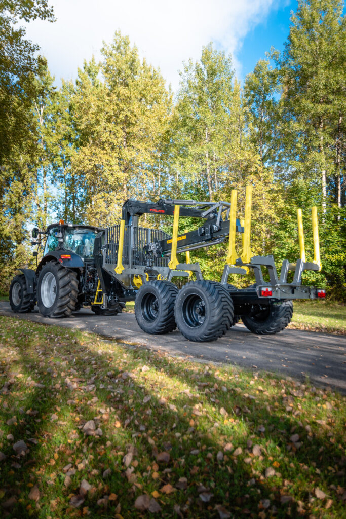 Palms 7.87 metsäkuormain ja kärry traktorin perässä kuljetusasennossa.
