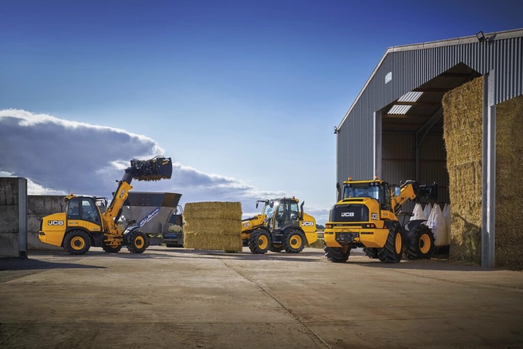 JCB-kuormainten ryhmäkuva maatilalla.