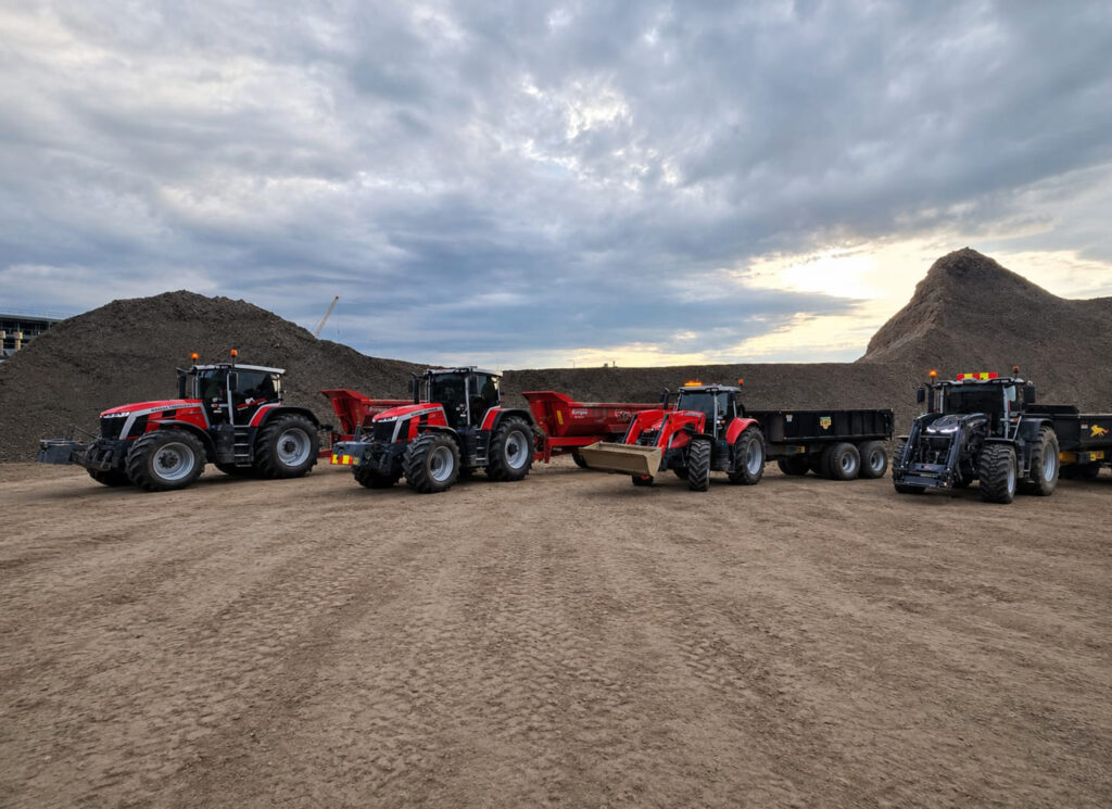 Neljä Massey Ferguson -traktoria maansiirtotyömaalla.