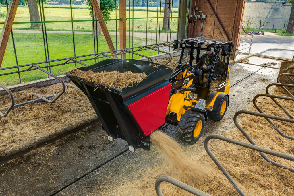 JCB 403 Agri -pyöräkuormaaja kuivittamassa navetan parsia.