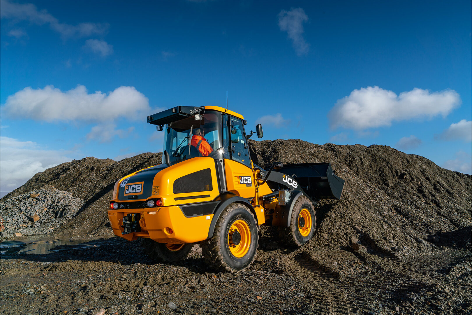 JCB 407 -pyöräkuormaaja nostamassa maata kuormaajalla.
