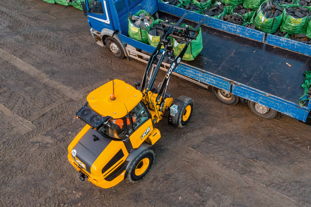 JCB 407 -pyöräkuormaaja nostamassa suursäkkejä peräkärrylle.