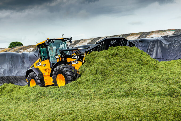 JCB 419S-pyöräkuormaaja siirtämässä rehua aumalla.