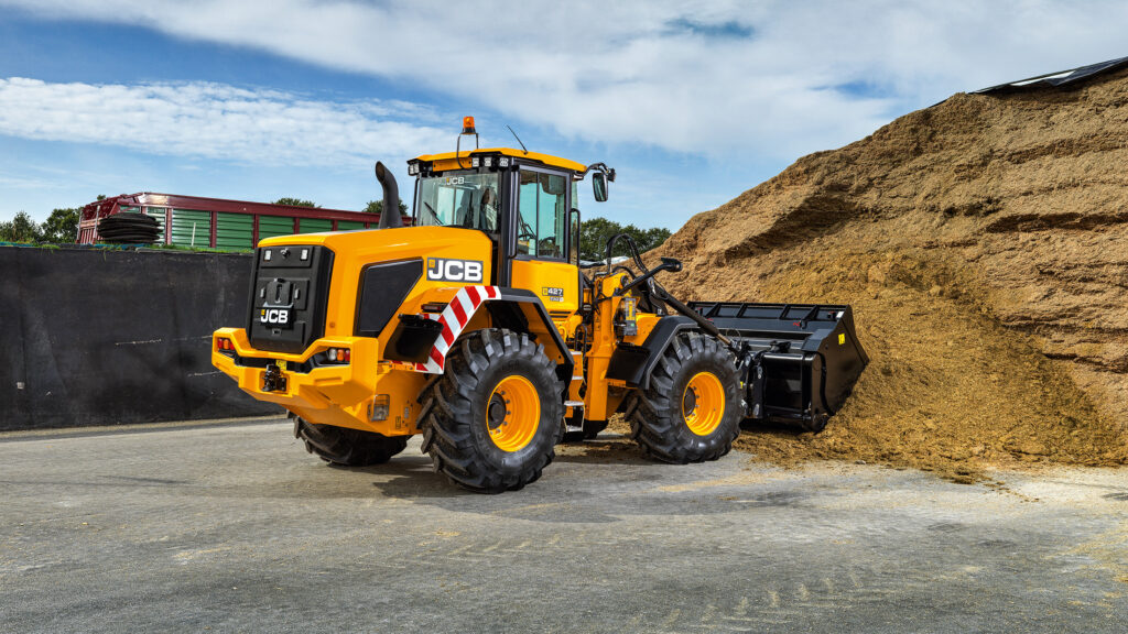 JCB 427 Agri-pyöräkuormaaja nostamassa rehua.