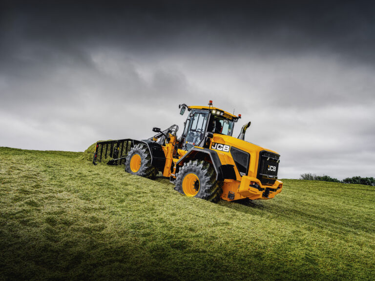 JCB 435S -pyöräkuormaaja aumalla työntämässä rehua.