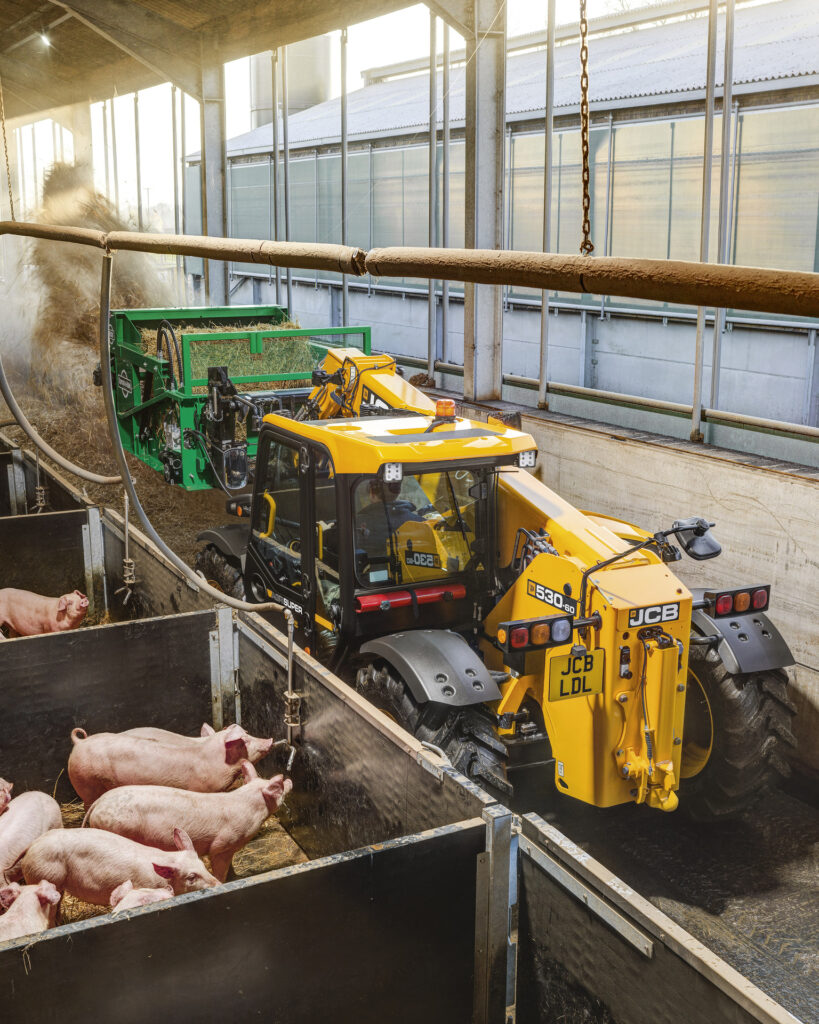 JCB 530-60 Agrisuper -kurottaja kuivittamassa sikalassa.
