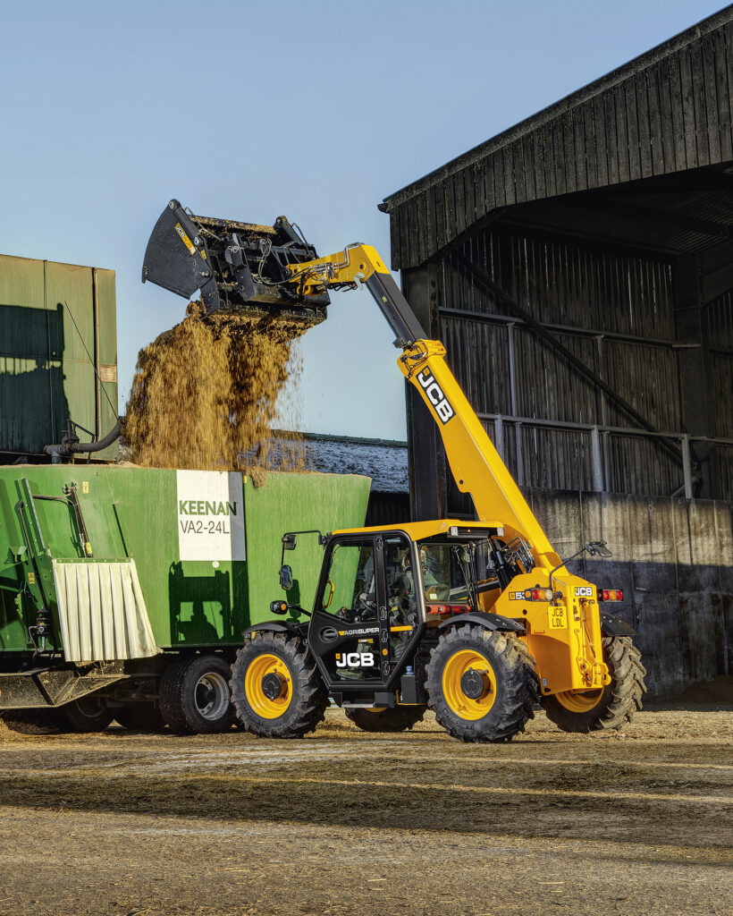 JCB 530-60 Agrisuper -kurottaja nostamassa rehua seosrehuvaunuun.