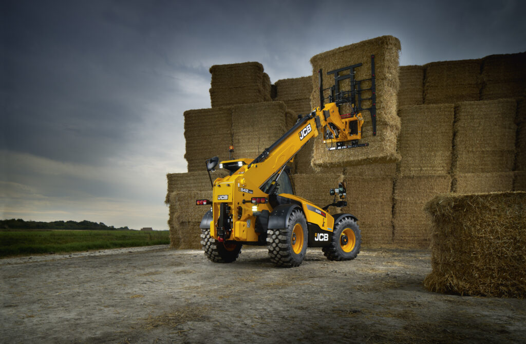 JCB 542-100 Agrisuper -kurottaja nostamassa olkipaaleja.
