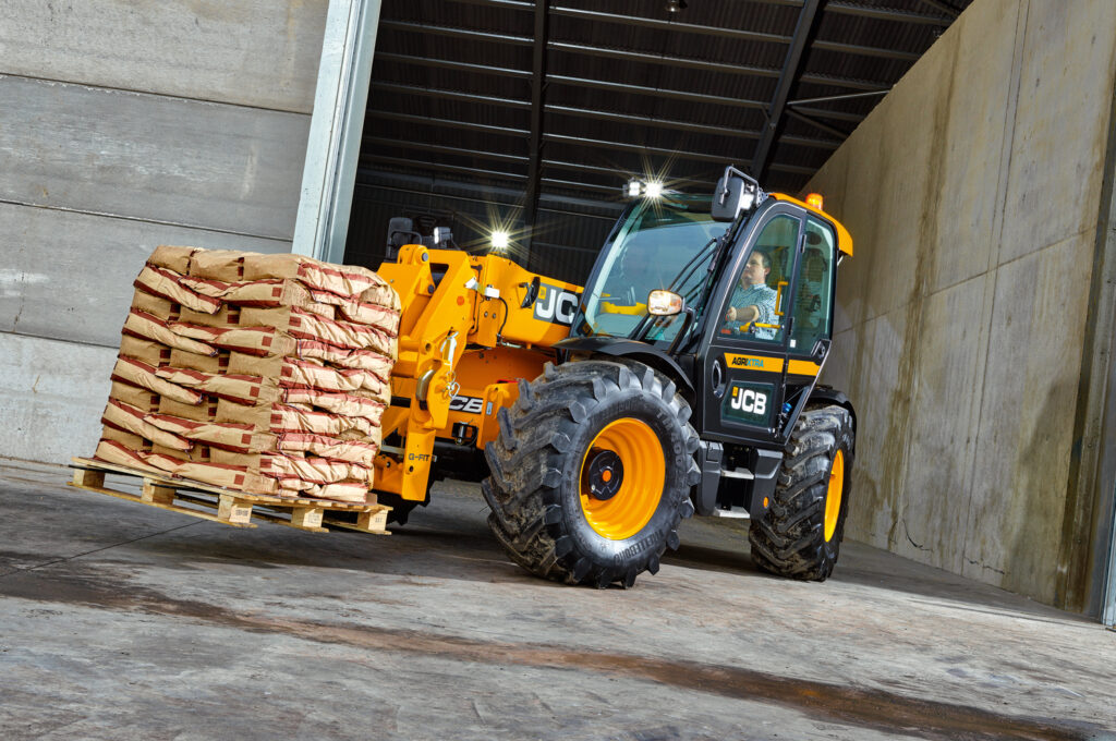 JCB 542-70 Agrisuper -kurottaja kantamassa trukkilavaa maatilalla.