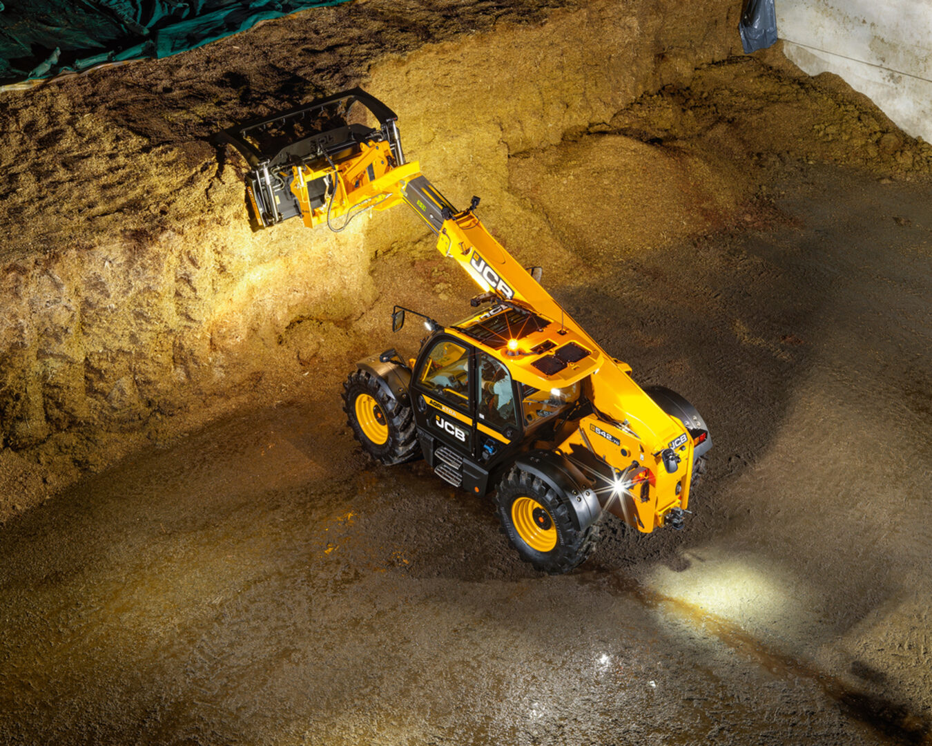 JCB 542-70 Agrisuper -kurottaja ottamassa rehua aumasta.