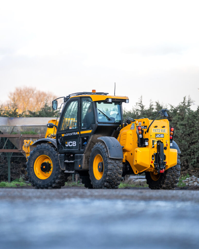JCB 560-80 Agri -kurottaja ajamassa maatilan pihassa.