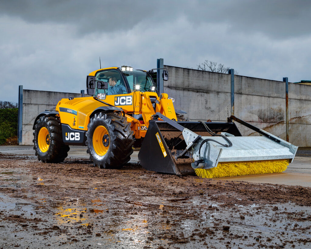 JCB 542-70 Agrisuper -kurottaja harjaamassa maatilan pihaa.