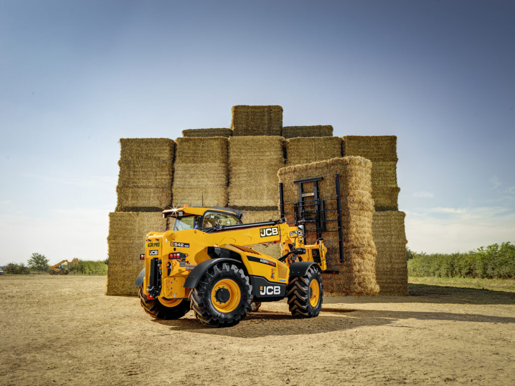JCB 542-100 Agrisuper -kurottaja nostamassa olkipaaleja.