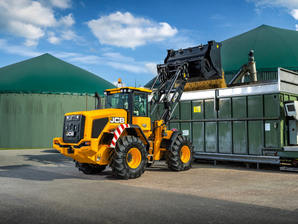 JCB 427 Agri-pyöräkuormaaja kippaamassa rehua kärryille.