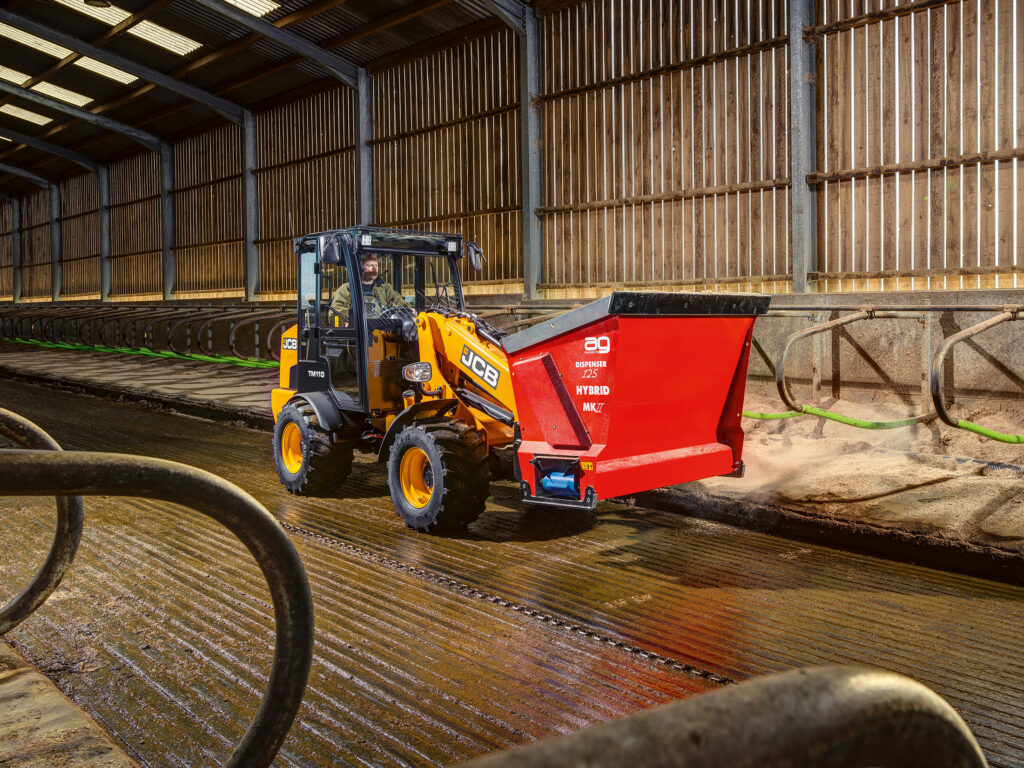 JCB TM110 Agri -kurottava pyöräkuormaaja kuivittamassa parsia navetassa.