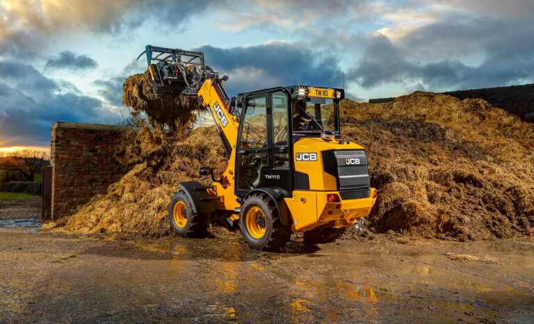 JCB TM110 Agri -kurottava pyöräkuormaaja nostamassa rehua.