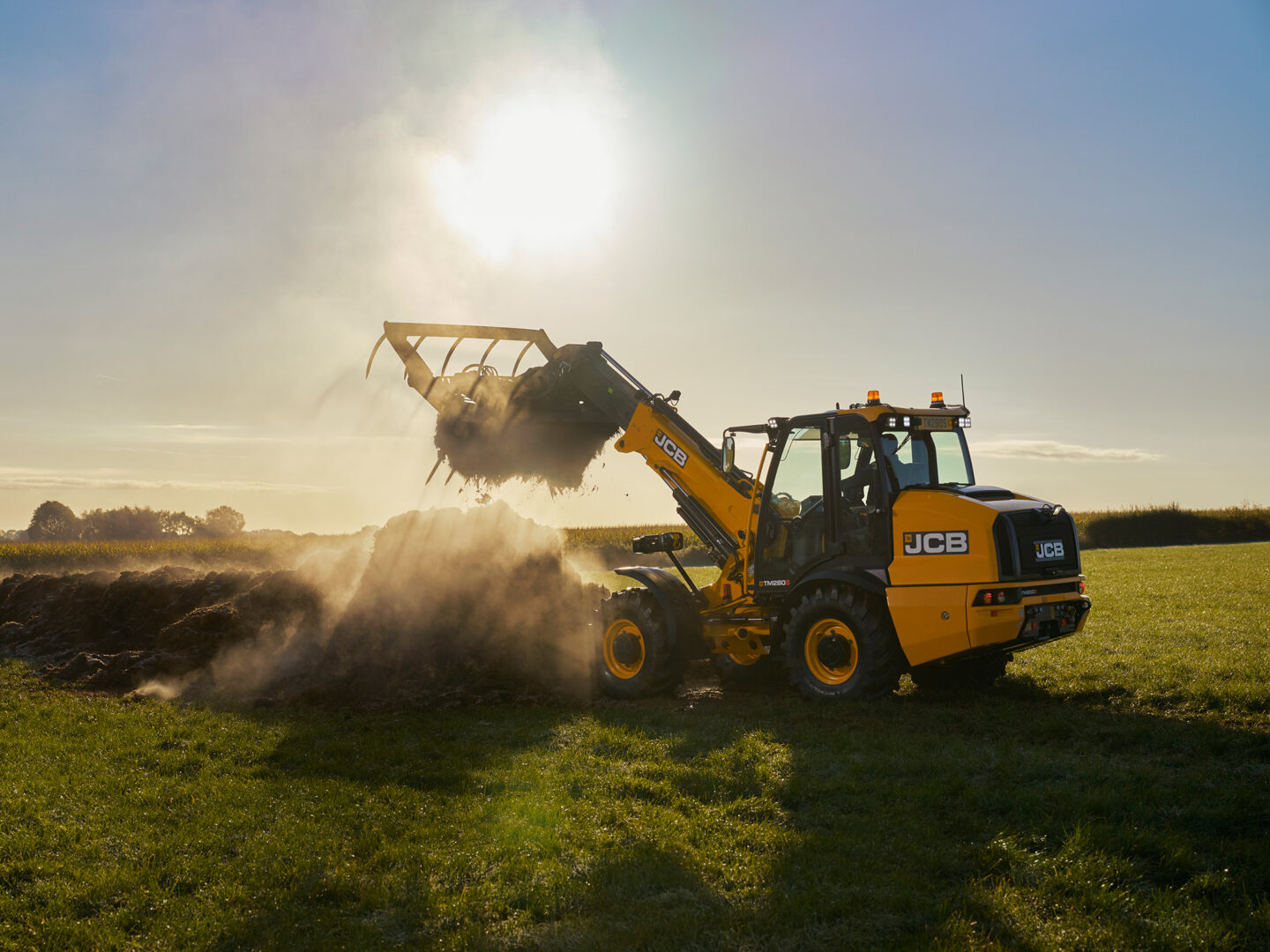 JCB TM280S Agri -kurottava pyöräkuormaaja pellolla tuomassa kuormaa.