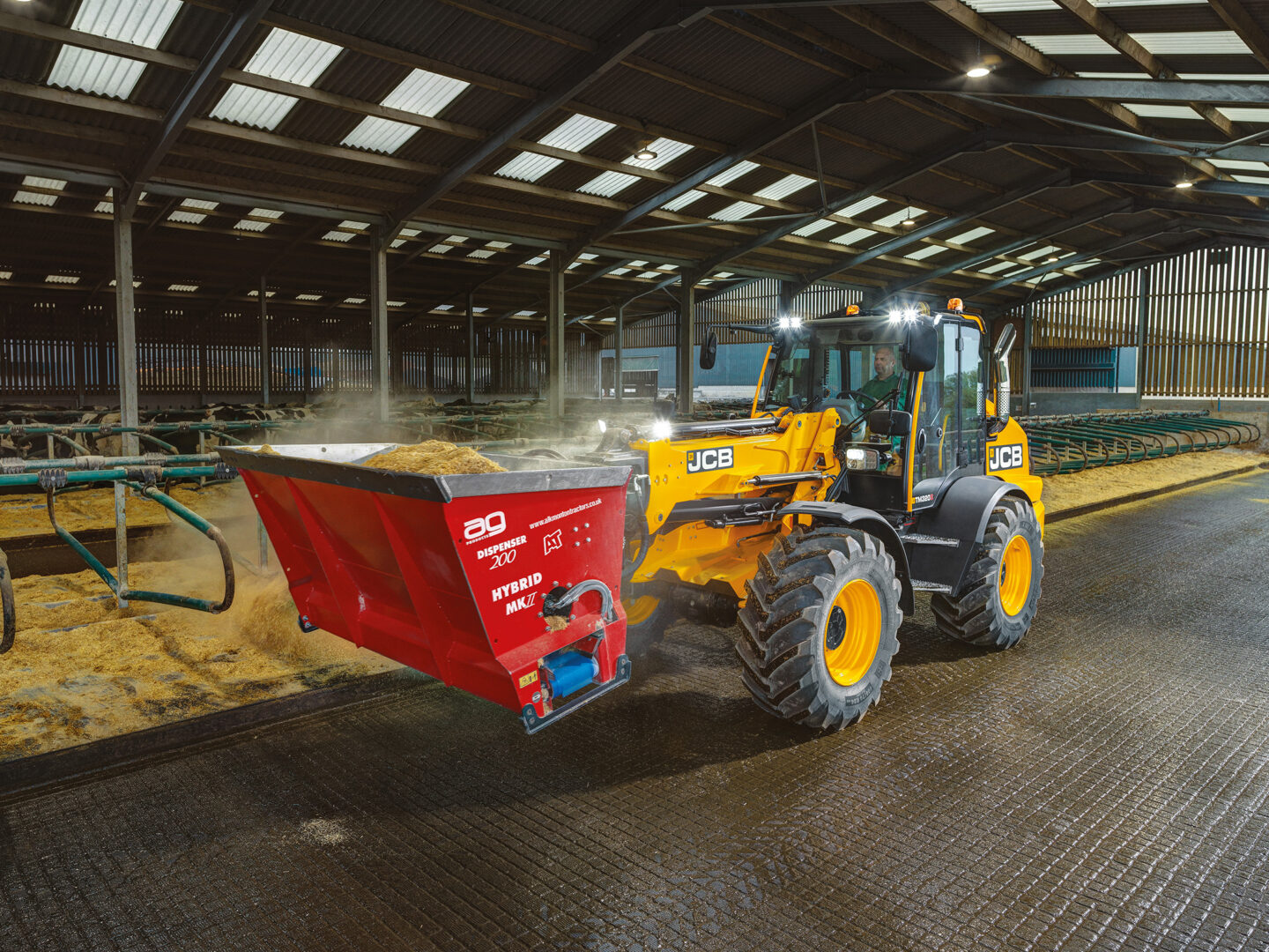 JCB TM320S Agri -kurottava pyöräkuormaaja kuivittamassa parsia navetassa.