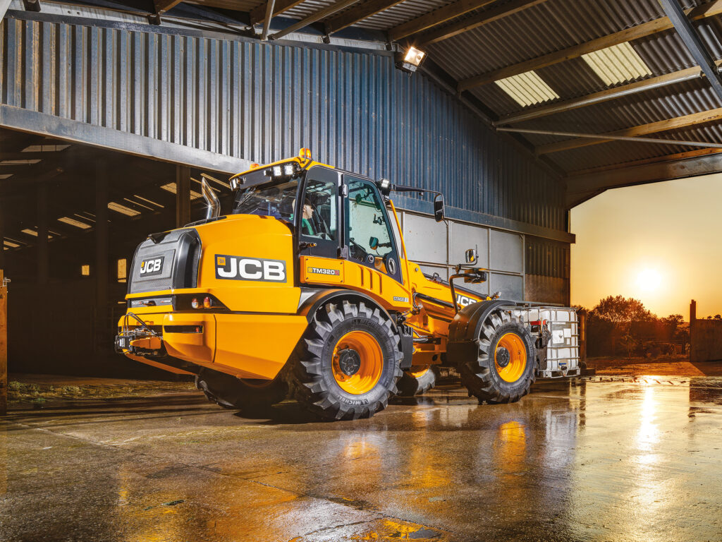 JCB TM320S Agri -kurottava pyöräkuormaaja kuljettamassa säiliötä.
