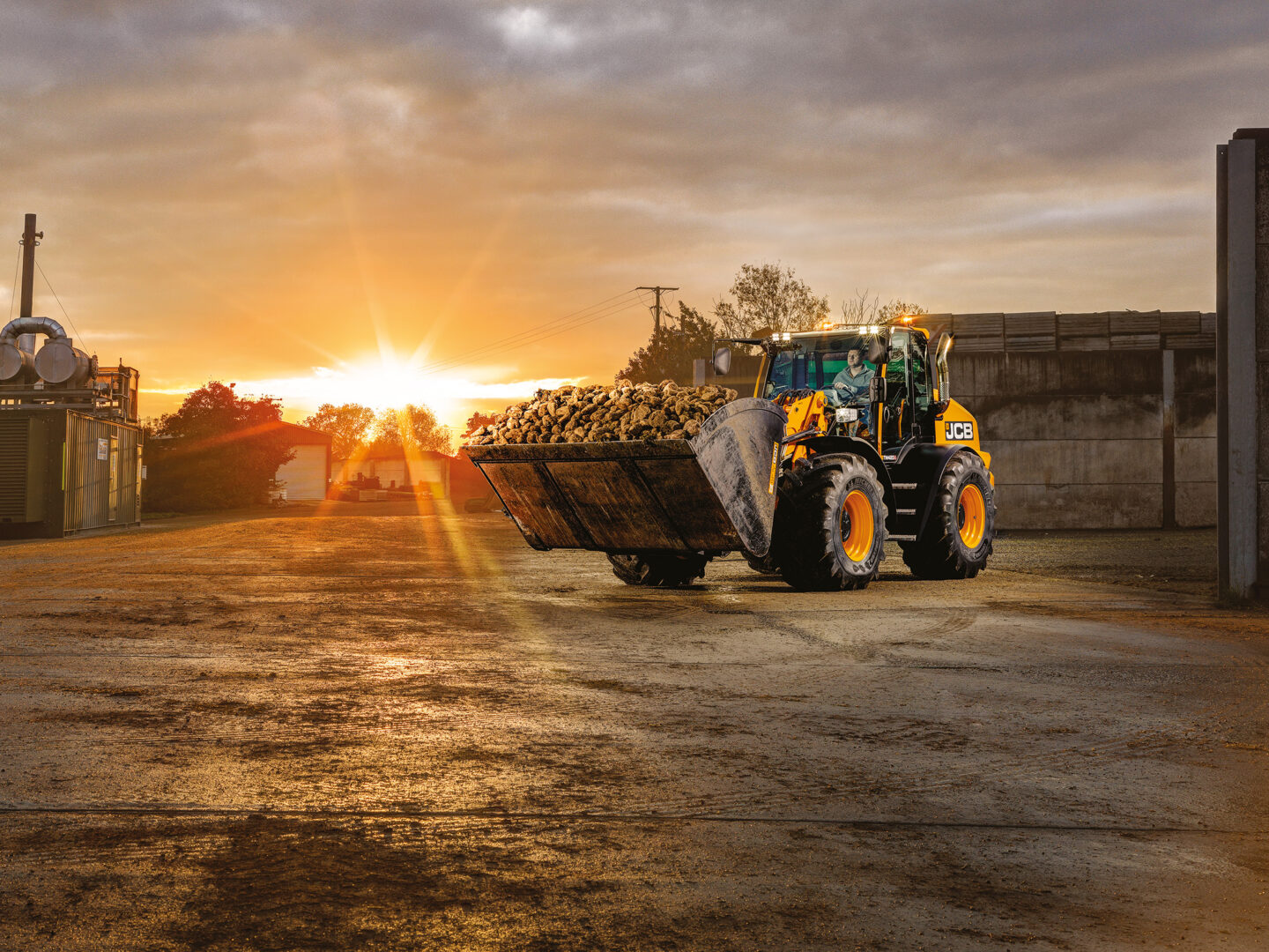JCB TM420S Agri -kurottava pyöräkuormaaja kuljettamassa maatilalla maakasaa.