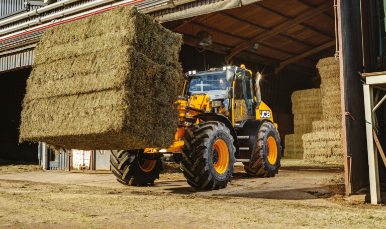 JCB TM420S Agri -kurottava pyöräkuormaaja kantamassa heinäpaaleja maatilalla.