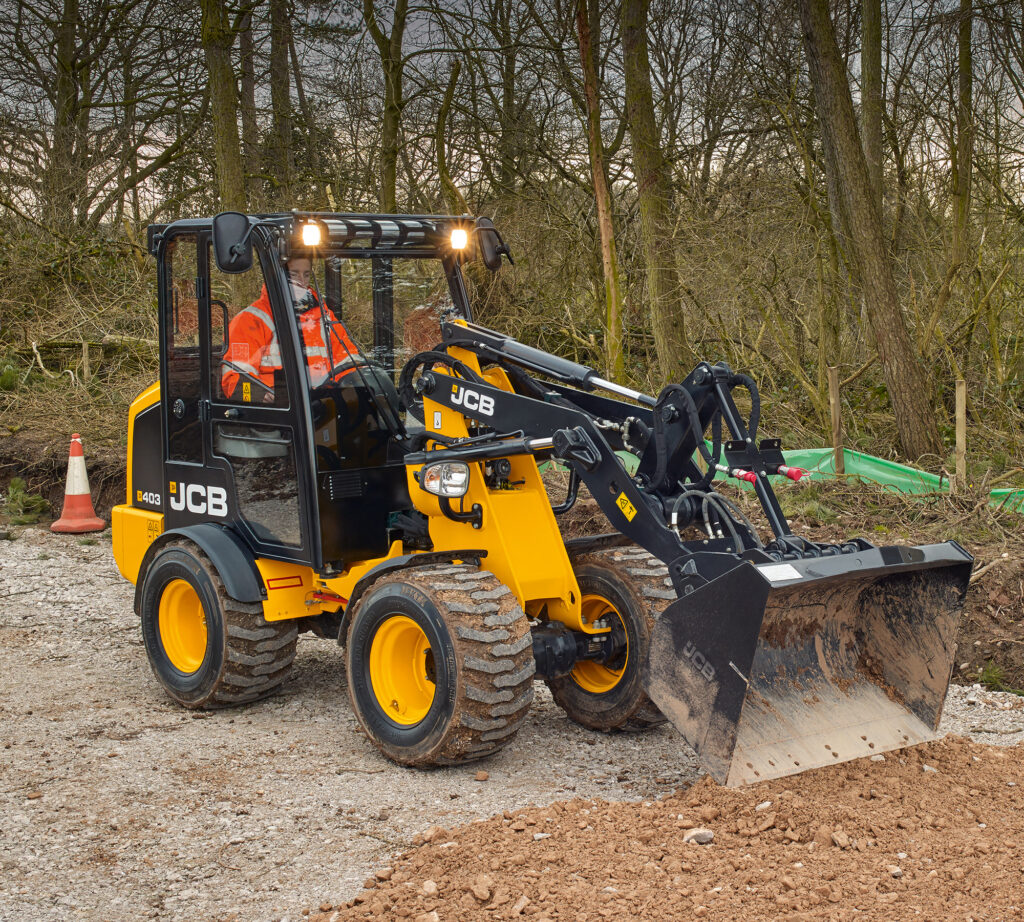 JCB 403 Agri -pyöräkuormaaja tasoittamassa maata kauhalla.